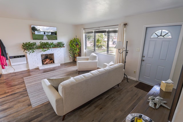 living area featuring baseboards, a fireplace, wood finished floors, and heating unit