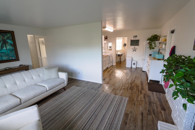 unfurnished living room featuring dark wood finished floors and baseboards