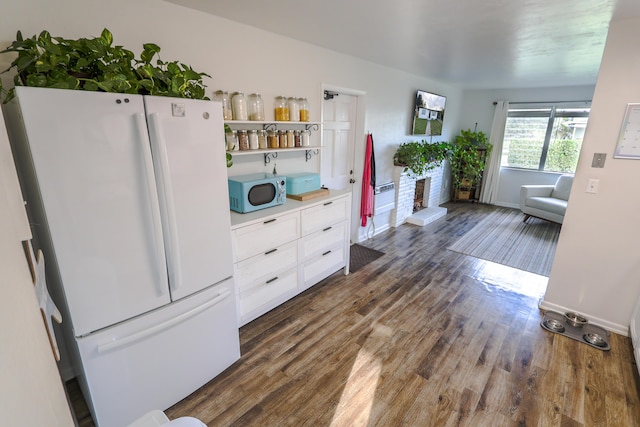 kitchen with dark wood-style floors, open shelves, light countertops, freestanding refrigerator, and white cabinets