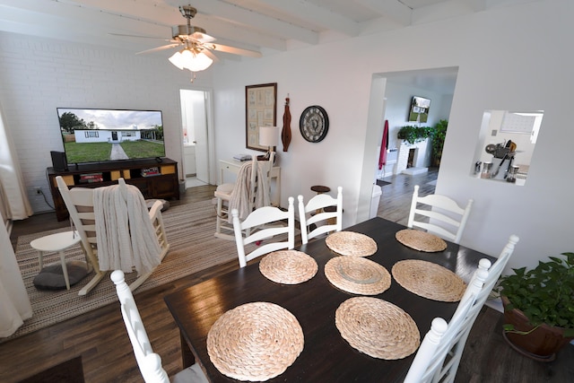 dining space with beam ceiling, a ceiling fan, and wood finished floors