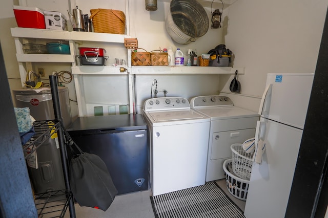 washroom featuring water heater, laundry area, and washing machine and clothes dryer