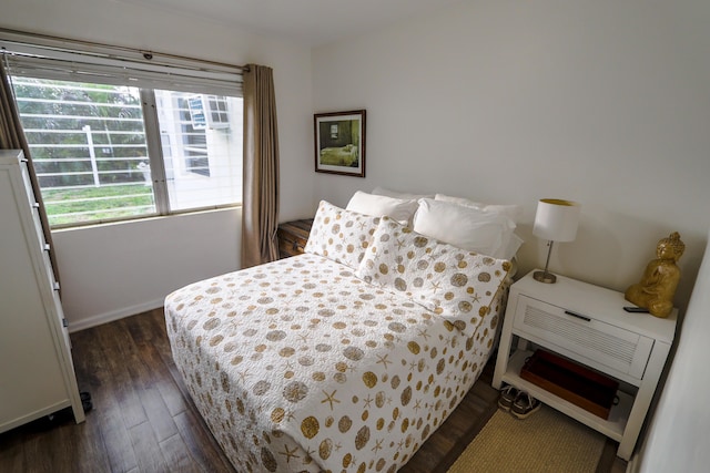 bedroom featuring baseboards and dark wood-style flooring