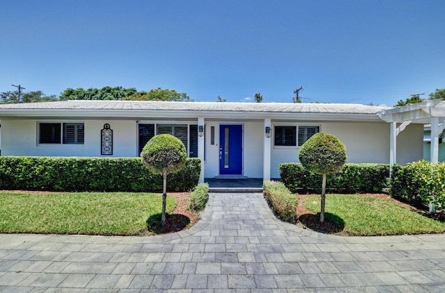 single story home with stucco siding and a front yard