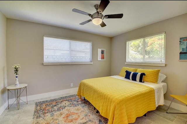 tiled bedroom featuring a ceiling fan and baseboards