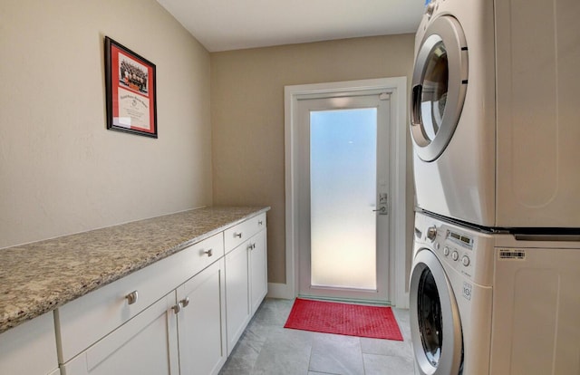 laundry area with cabinet space and stacked washing maching and dryer