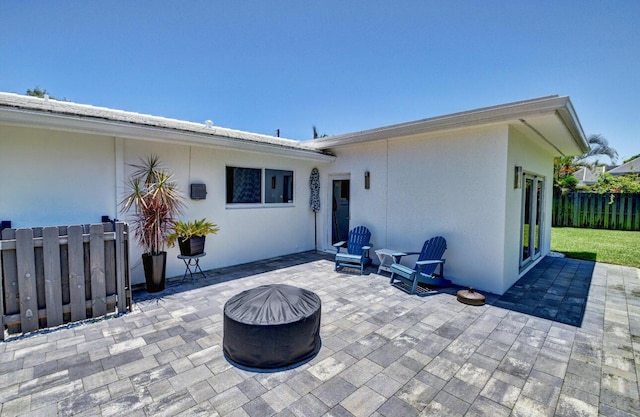 back of property with a patio area, stucco siding, fence, and an outdoor fire pit