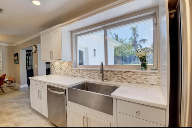 kitchen with a sink, decorative backsplash, ornamental molding, white cabinets, and stainless steel appliances