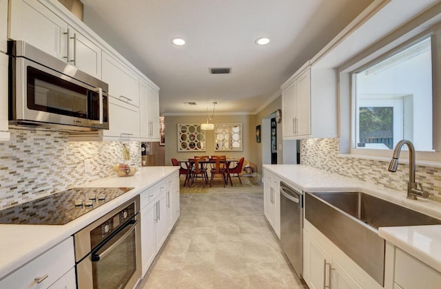 kitchen featuring a sink, stainless steel appliances, white cabinets, and light countertops