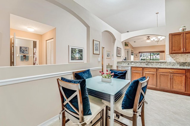 dining area with arched walkways, light tile patterned floors, and a notable chandelier