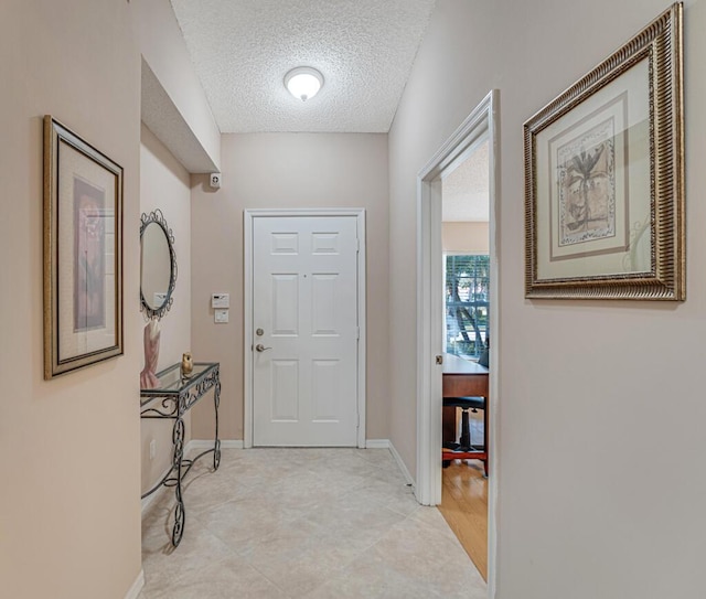 entryway featuring baseboards and a textured ceiling