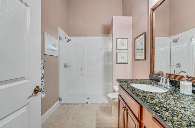 bathroom with toilet, a shower stall, and vanity