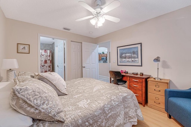 bedroom featuring a textured ceiling, visible vents, a ceiling fan, a closet, and light wood-type flooring