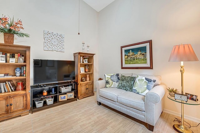 living room featuring a towering ceiling and baseboards