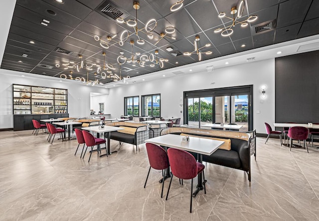 dining area featuring marble finish floor, a towering ceiling, and visible vents