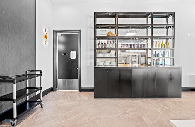 bar with indoor wet bar and baseboards