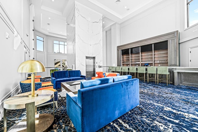 living area with a healthy amount of sunlight, a towering ceiling, crown molding, and recessed lighting