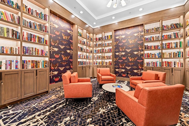 sitting room featuring recessed lighting, wall of books, and wallpapered walls