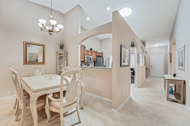 dining area featuring an inviting chandelier, baseboards, light tile patterned floors, and arched walkways