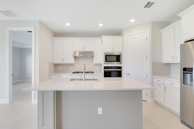 kitchen featuring light countertops, visible vents, appliances with stainless steel finishes, light tile patterned flooring, and under cabinet range hood