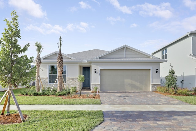 view of front of home with a garage, stone siding, stucco siding, decorative driveway, and a front yard