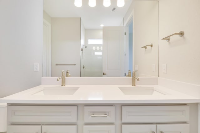 bathroom featuring double vanity, a sink, and a walk in shower