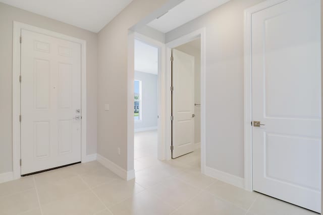 entryway with light tile patterned floors and baseboards