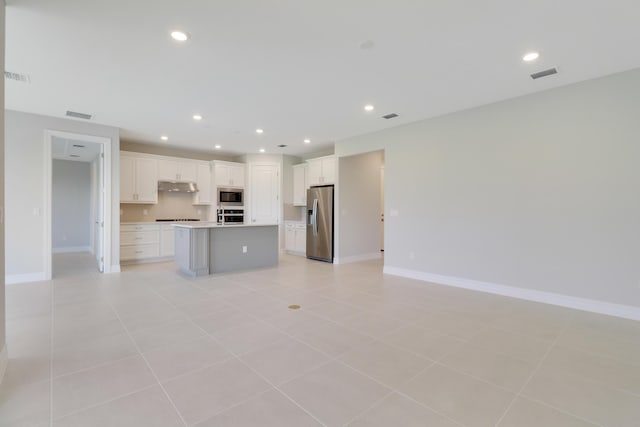 kitchen featuring open floor plan, stainless steel appliances, visible vents, and under cabinet range hood