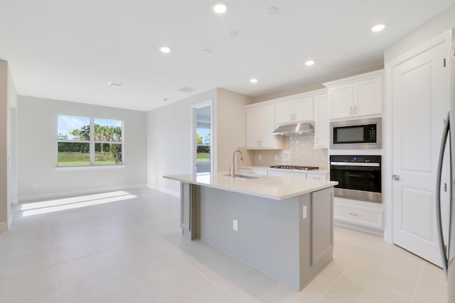 kitchen featuring stainless steel gas cooktop, a sink, built in microwave, oven, and under cabinet range hood