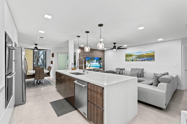 kitchen featuring visible vents, modern cabinets, open floor plan, stainless steel appliances, and a sink