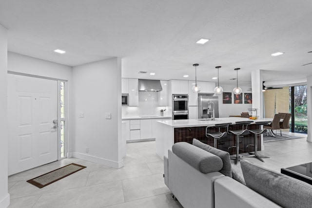 living room with a ceiling fan, recessed lighting, baseboards, and light tile patterned floors