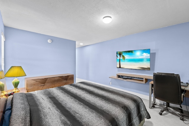 bedroom featuring baseboards and a textured ceiling