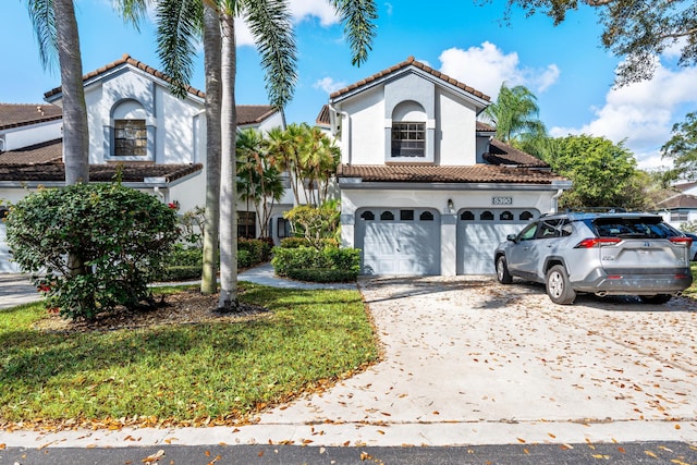 mediterranean / spanish-style home with a tile roof, driveway, and stucco siding