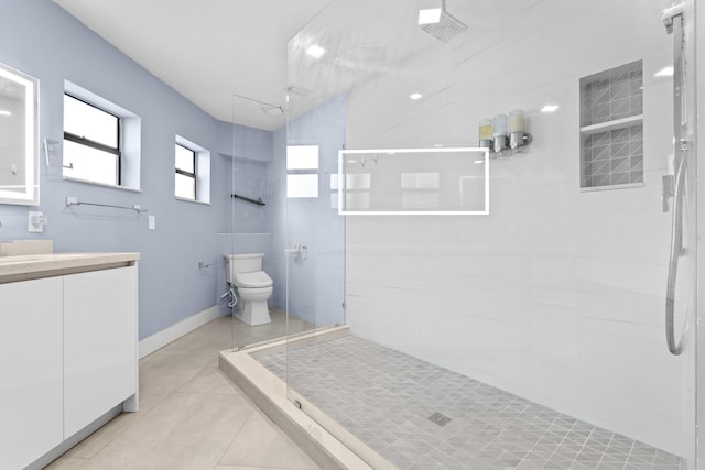 full bathroom featuring baseboards, toilet, tile patterned floors, walk in shower, and vanity