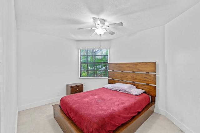 bedroom featuring ceiling fan, a textured ceiling, and baseboards