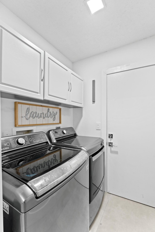 clothes washing area featuring cabinet space and washing machine and clothes dryer