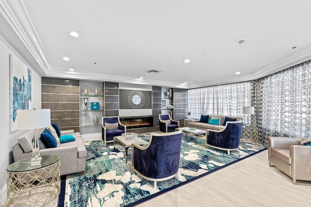 living area featuring visible vents, wood finished floors, crown molding, a fireplace, and recessed lighting