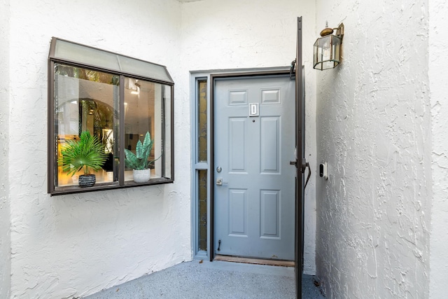 view of exterior entry featuring stucco siding