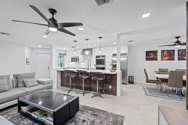 living room featuring ceiling fan, visible vents, and light tile patterned flooring