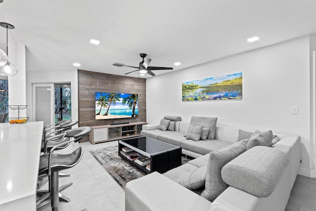 living room featuring wood walls, an accent wall, a ceiling fan, and recessed lighting