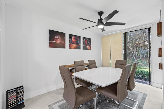 dining area with expansive windows, ceiling fan, and baseboards