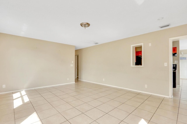 spare room featuring visible vents, baseboards, and light tile patterned floors