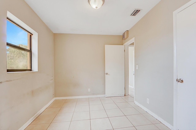 empty room featuring visible vents, baseboards, and light tile patterned floors