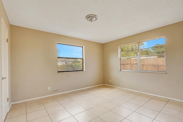 unfurnished room featuring a textured ceiling and baseboards