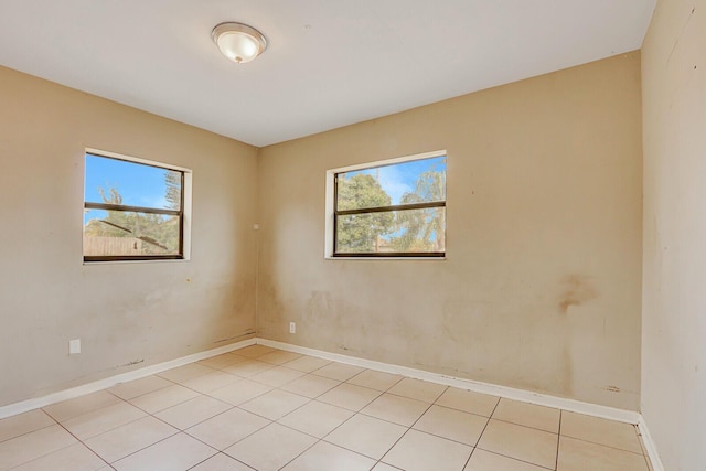 empty room featuring plenty of natural light and baseboards