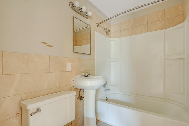 bathroom with toilet,  shower combination, and tile walls