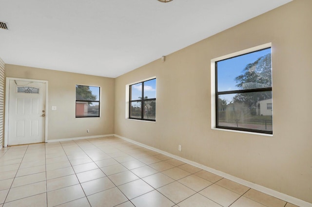 spare room with light tile patterned floors, visible vents, and baseboards