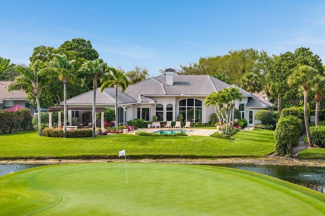 back of property featuring a chimney, an outdoor pool, a patio, and a yard