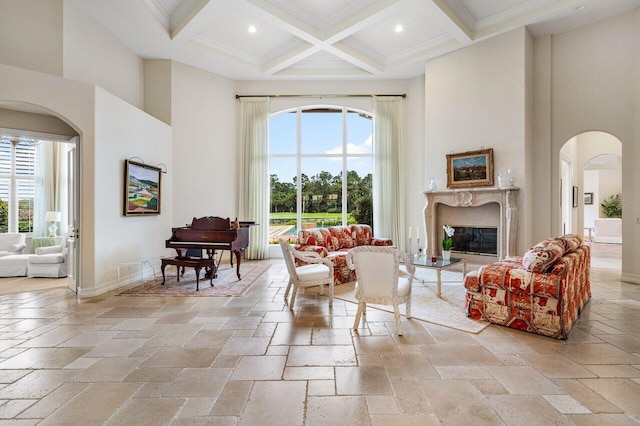 7500 Marsh Cv, Palm Beach Gardens, FL 33418 - living room featuring a towering ceiling, healthy amount of natural light, stone tile flooring, beamed ceiling, and arched walkways