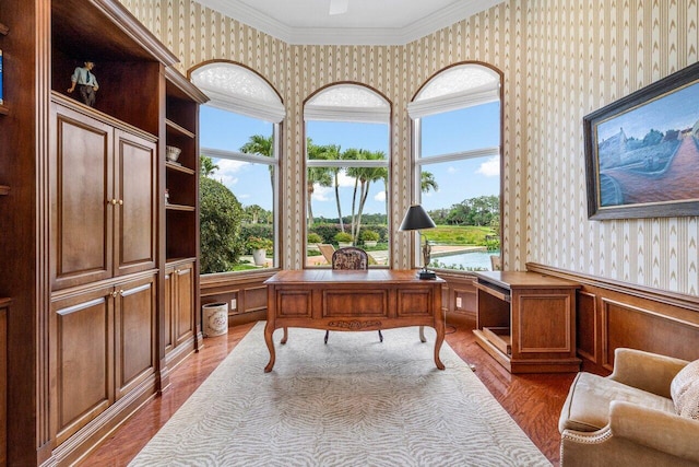 home office featuring dark wood-style floors, a wainscoted wall, crown molding, and wallpapered walls