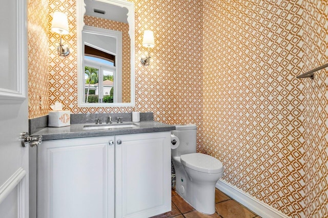 bathroom featuring visible vents, toilet, vanity, tile patterned flooring, and wallpapered walls